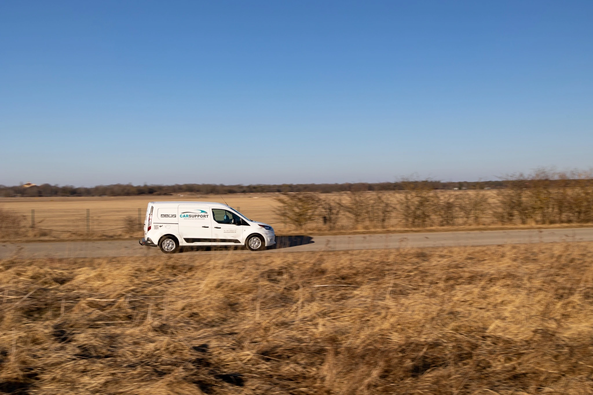 CarSupport-Servicefahrzeug auf einer Landstraße zwischen Feldern